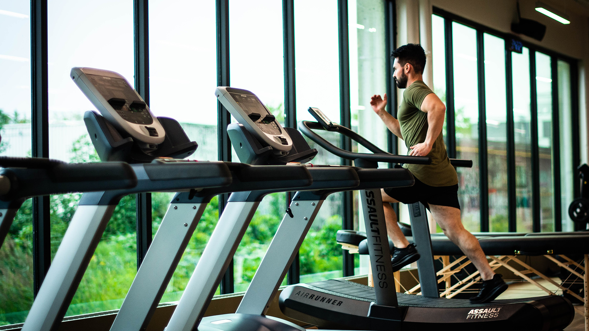 Image of a man in a gym running on a treadmill